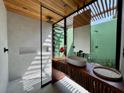 Un baño con lavabo y una gran ventana. en Umbelina Pousada Boutique, en Porto de Galinhas