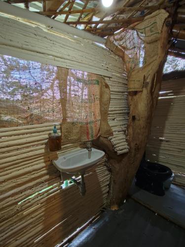 a bathroom with a sink in a wooden wall at Hospedaje casa en el Árbol in Moniquirá