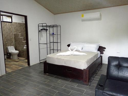 a bedroom with a bed and a bathroom with a toilet at Pino Longe, Río Celeste in Upala