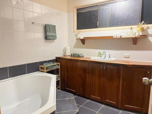 a bathroom with a bath tub and a sink at Tranquil Hideaway in Mudgeeraba in Gold Coast