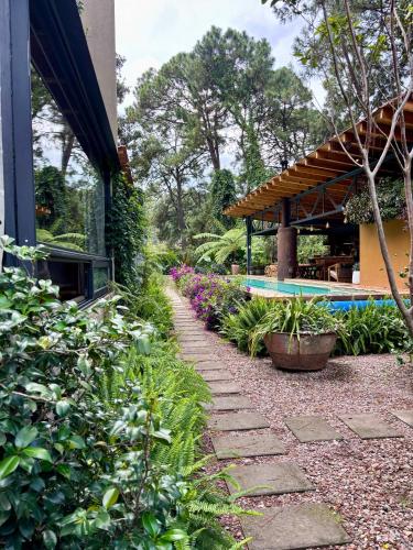 a garden with a stone walkway next to a building at Pandurata Bed and Breakfast in Valle de Bravo