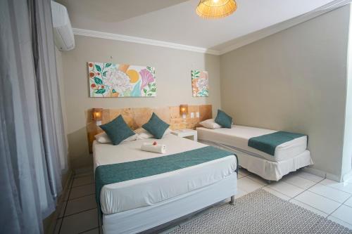 a hotel room with two beds and a couch at Pousada Hippopotamus Jeri in Jericoacoara