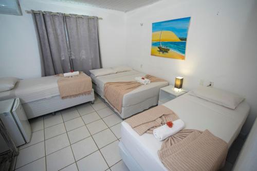 a hotel room with two beds and a couch at Pousada Hippopotamus Jeri in Jericoacoara