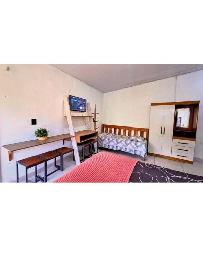 a room with a desk and a bed and a table at Hospedaria Caripí in Barcarena