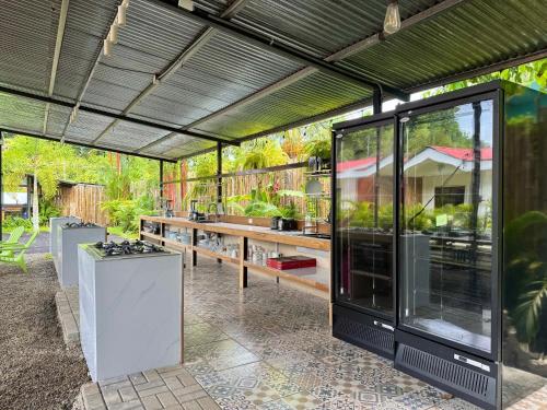 an outdoor kitchen with a large glass building at Kalunay Hostel - Breakfast included in Puerto Viejo