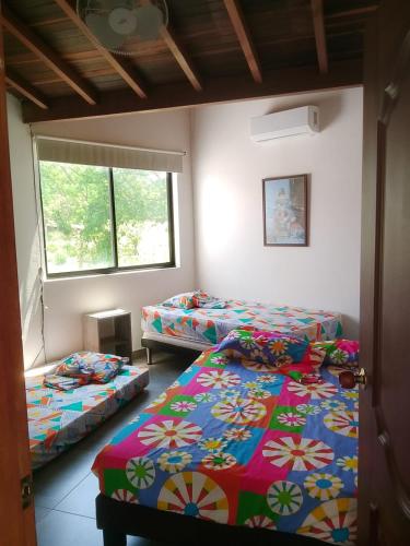 a room with two beds and a window at Casa Lili in Sopetrán
