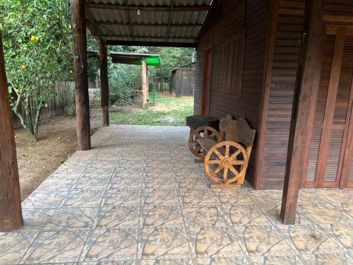 ein hölzerner Karren neben einem Gebäude in der Unterkunft Sítio reservado com piscina in Viamão
