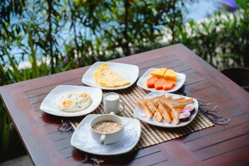 a table with plates of breakfast food on it at Kubu Kak Dudung Villas in Jimbaran
