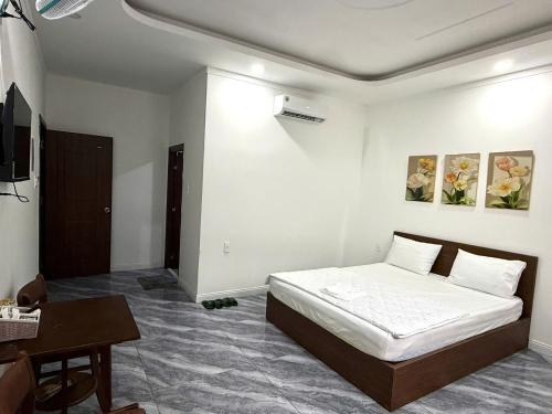 une chambre avec un lit, une table et un bureau dans l'établissement Hotel Bảo Bảo, à Thuan An