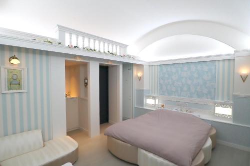 a bedroom with a bed and a chair in it at ホテルロンシャンーAdult onlyー 