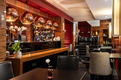 a restaurant with tables and chairs and a bar at Starhotels Ritz in Milan