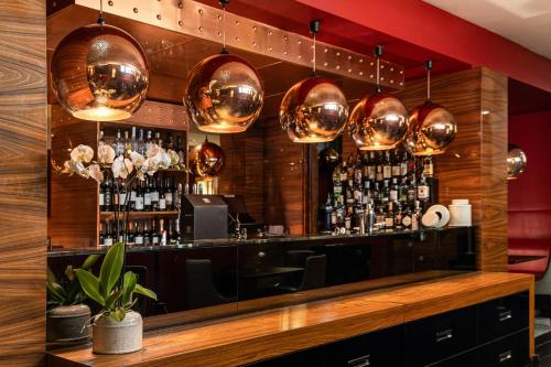 a bar with copper pendant lights and a counter at Starhotels Ritz in Milan