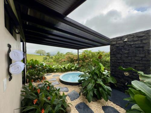 une terrasse avec un bain à remous et quelques plantes dans l'établissement Villa Guarumo, à Santa Eulalia