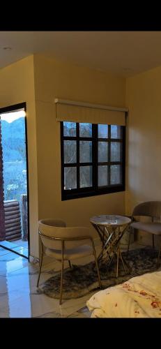 a room with two tables and chairs and a window at عزبة وادي السدر in ‘Ashashah