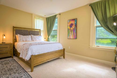 a bedroom with a large bed and two windows at Westcott 3 Bed Apt in Mansion mins to SU JMA Dome in Syracuse