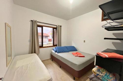 a small bedroom with a bed and a window at Quintal do Beto Carreiro/450m praia+wifi+ArCondici in São Lídio