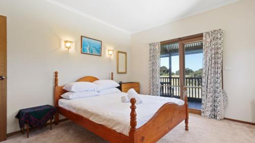 a bedroom with a bed and a balcony at Halcyon - Peaceful Family Retreat in Nungurner
