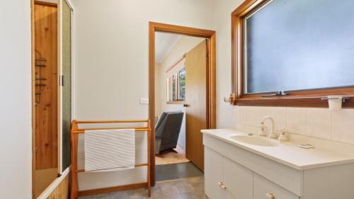 a bathroom with a sink and a mirror at Halcyon - Peaceful Family Retreat in Nungurner