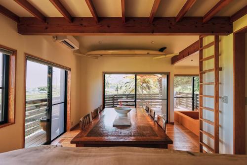 a dining room with a table and some windows at Umiyama Chikura in Minamiboso
