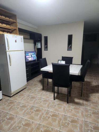Una cocina con un refrigerador blanco y una mesa y sillas. en la pipi, en Las Heras
