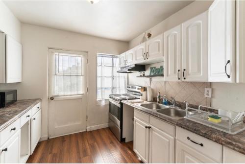 a kitchen with white cabinets and a sink and a stove at *Free Parking near Strip Cozy 2Br home Side: A in Las Vegas