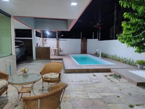 einen Pool auf einer Terrasse mit Stühlen und einem Tisch in der Unterkunft Casa em Olinda com piscina para o carnaval in Olinda