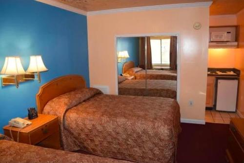 a hotel room with three beds with blue walls at Fort Eustis INN in Newport News