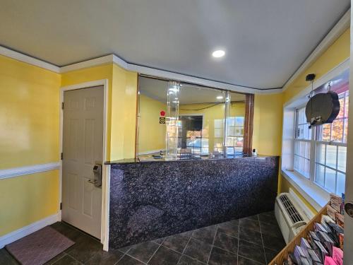 a bathroom with yellow walls and a large mirror at Fort Eustis INN in Newport News