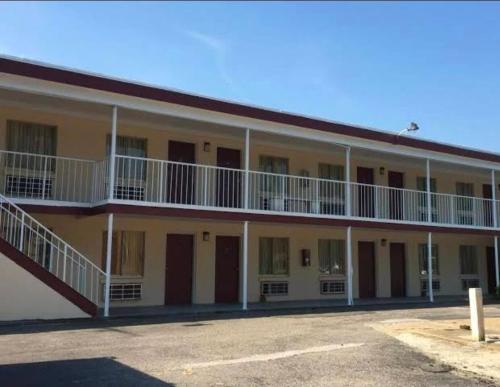 a large yellow building with white balconies at Fort Eustis INN in Newport News