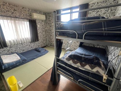 a bunk bed room with two bunk beds in it at Guesthouse Tiga in Kumamoto