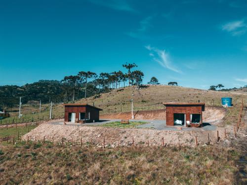 a house on top of a hill in a field at Pousada Invernada in São Joaquim