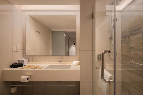 a bathroom with a sink and a mirror at The Federal Kuala Lumpur in Kuala Lumpur