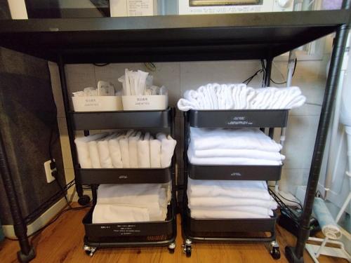 ein Handtuchhalter mit weißen Handtüchern darauf in der Unterkunft ゲストハウスsimasima古馬場301 in Takamatsu