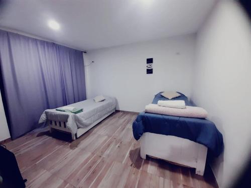 a bedroom with two beds and a wooden floor at Oceana Suites Elisio Mouriño in La Unión