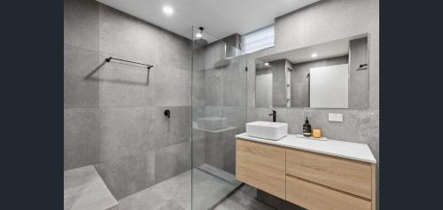 a bathroom with a shower and a sink and a mirror at Riviera Noosa Resort in Noosaville