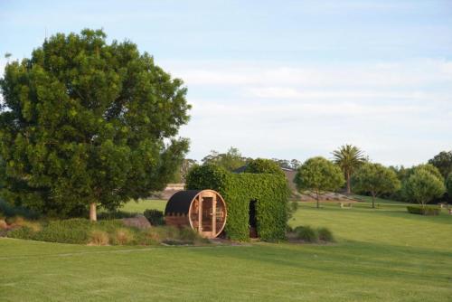 a circular shed in a field with a tree at Linnaeus Farm, Berry - by Linnaeus Collection in Berry