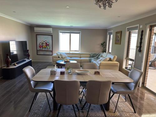 a living room with a table and a couch at Tarneit Treasure in Tarneit