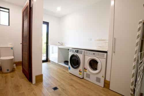a laundry room with a washer and dryer in it at The Barrington in South Mission Beach