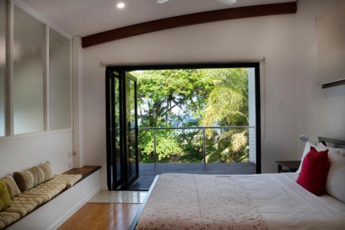 a bedroom with a large bed and a sliding glass door at The Barrington in South Mission Beach