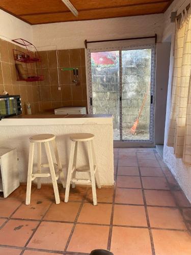a kitchen with two stools in front of a counter at Monoambiente Caracol chico in Aguas Dulces