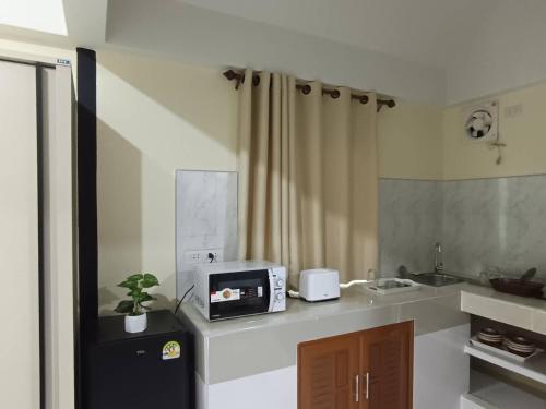 a small kitchen with a microwave on a counter at Lanta summer house nui bay in Ko Bu Bu