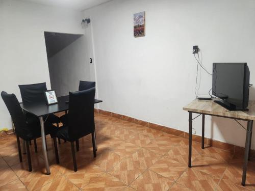 a room with a table and chairs and a tv at alojamiento la pipi in Las Heras