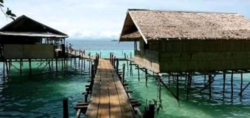 eine Gruppe von Gebäuden im Wasser nahe dem Meer in der Unterkunft Full Board Raja Ampat Sanara Homestay in Waisai
