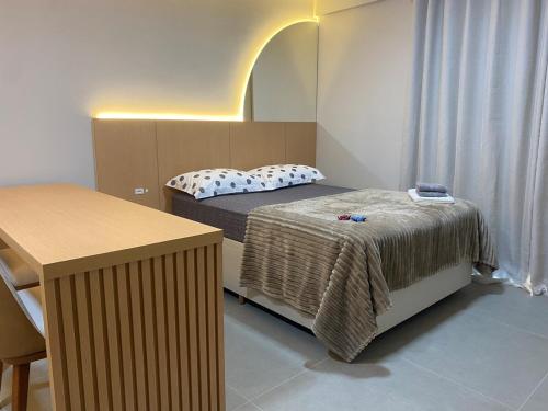 a small room with a bed and a table at LINDO LOFT 350m Vila Germânica in Blumenau