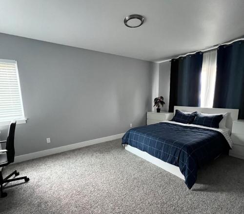 a bedroom with a blue bed and a window at Cozy and stylish 3BR house in Tacoma