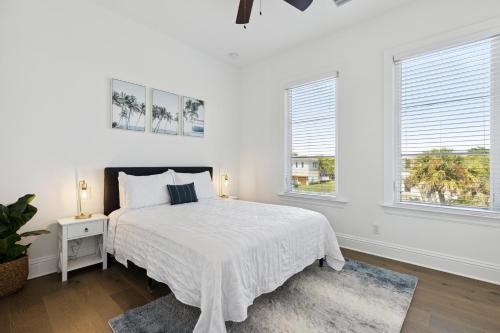a white bedroom with a bed and two windows at 139 Ocean Estates Dr in Lakewood Park