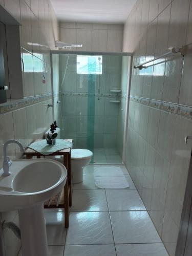 a bathroom with a shower and a sink and a toilet at Residencial lara 101 in Itapema