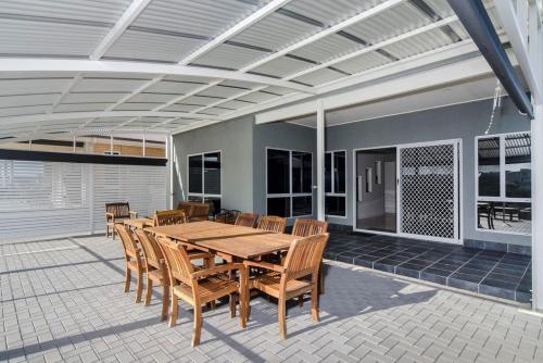 a wooden table and chairs on a patio at Isla Bonita - Pet Friendly - Not Fully Fenced - No Linen Included in Hindmarsh Island