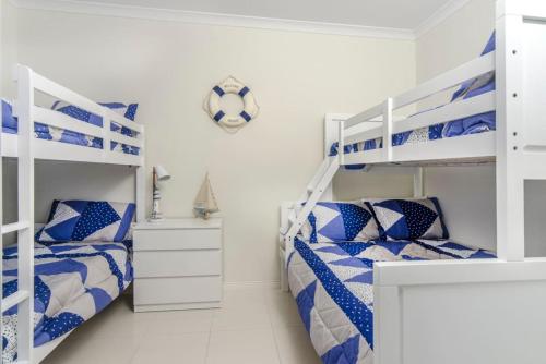 two beds in a white room with bunk beds at Isla Bonita - Pet Friendly - Not Fully Fenced - No Linen Included in Hindmarsh Island