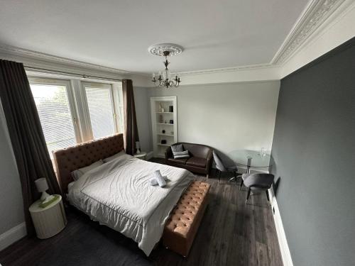 a bedroom with a bed and a chair and a table at Immanuel House - Modern Luxury Victorian Home 1872 - Free Parking & SuperFast Fibre Optic WiFi in Edinburgh